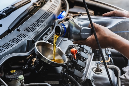 a mechanic tightening a bolt in a car hood